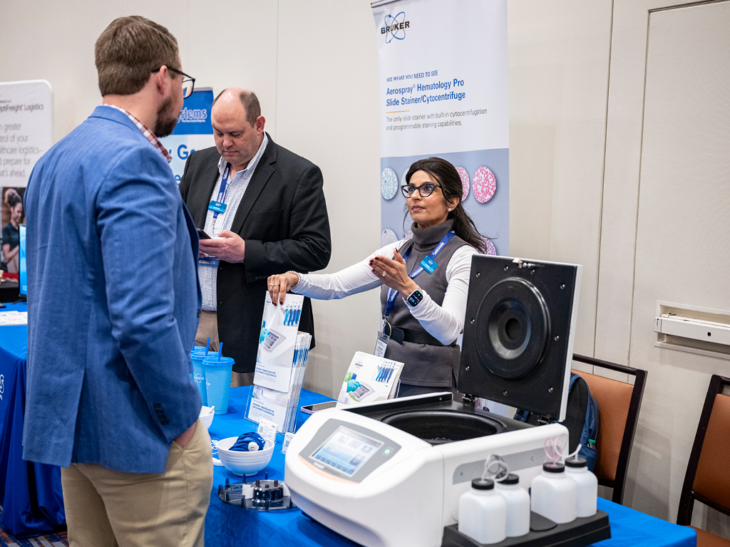 Leadership Summit attendees at an exhibit booth discussing solutions with an exhibiting organization