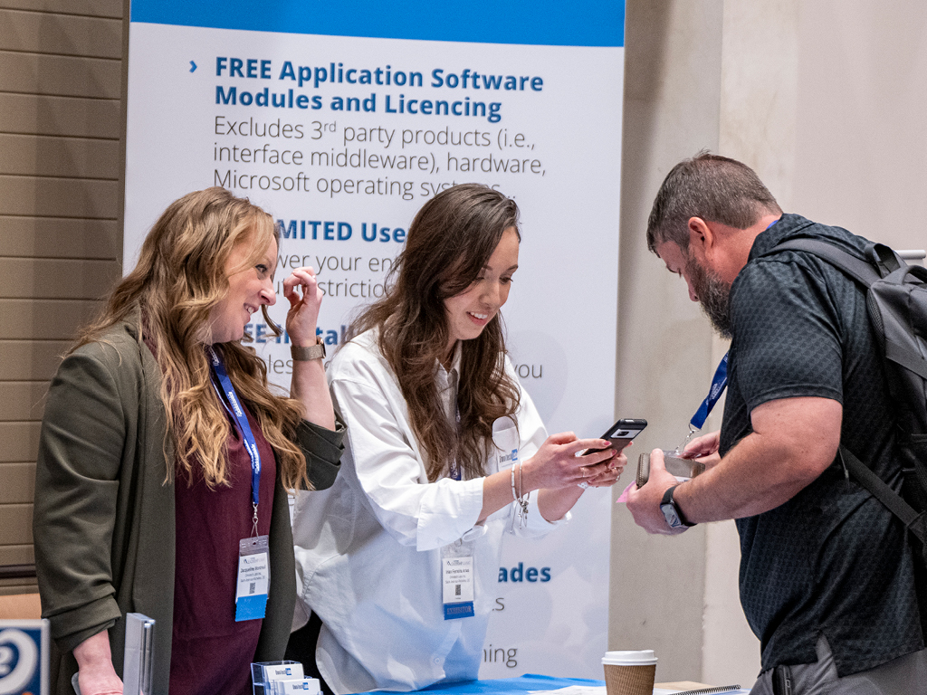 Exhibitors scanning an attendee badge at the Leadership Summit exhibit hall